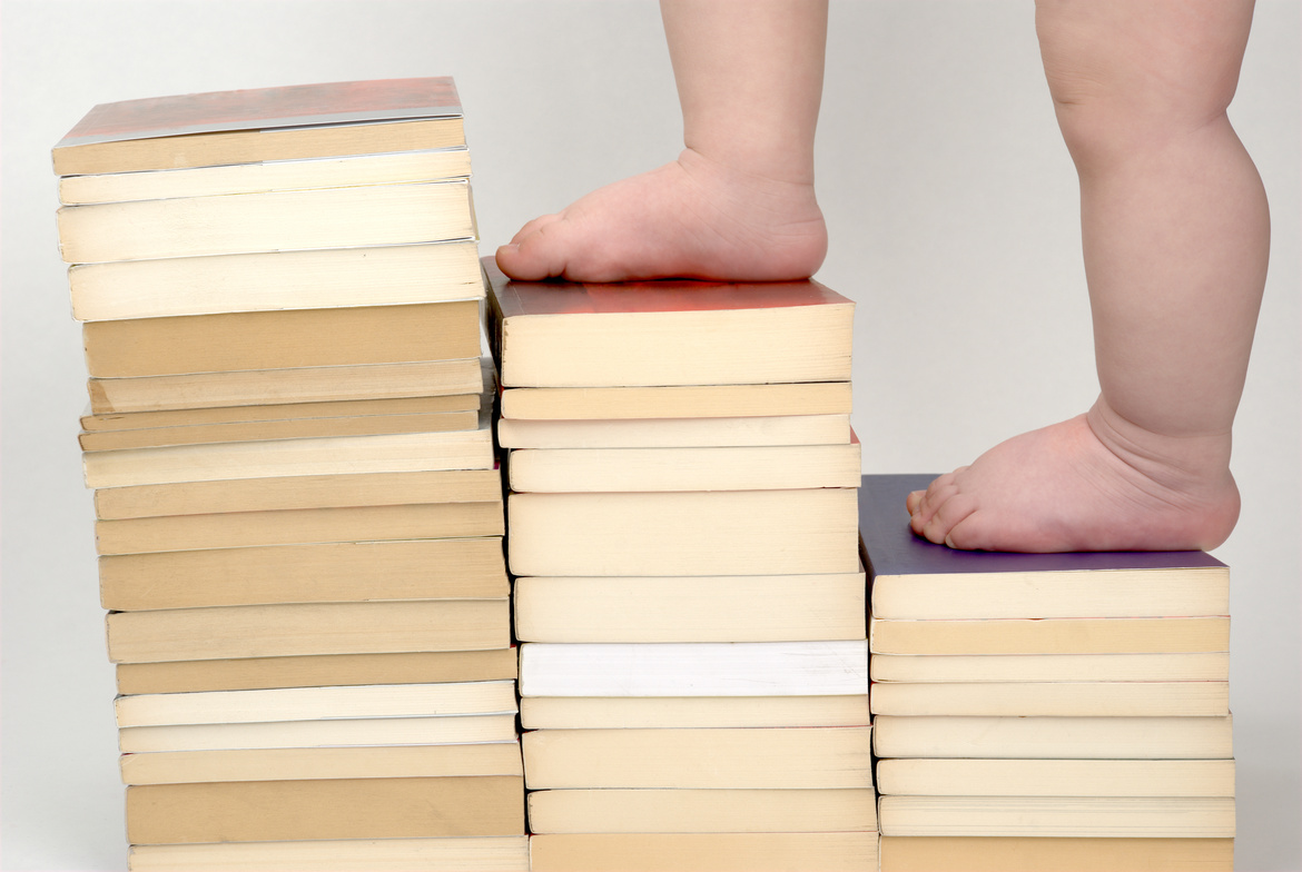 baby walking up on books